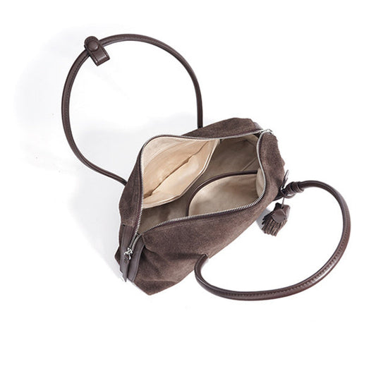 Brown leather bag with a strap on a white background