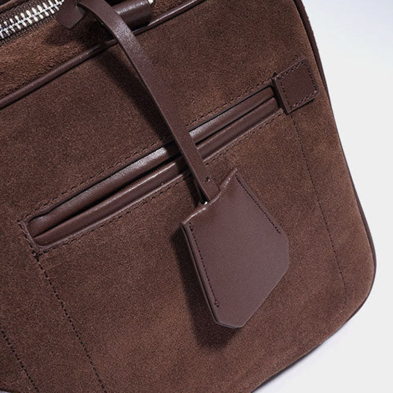 Brown leather bag with precision stitches on a white background