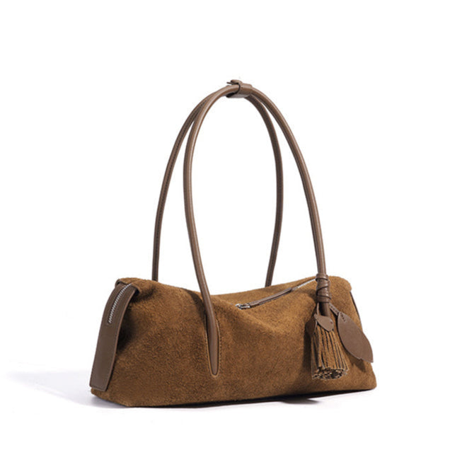 Brown suede handbag with tassels on a white background